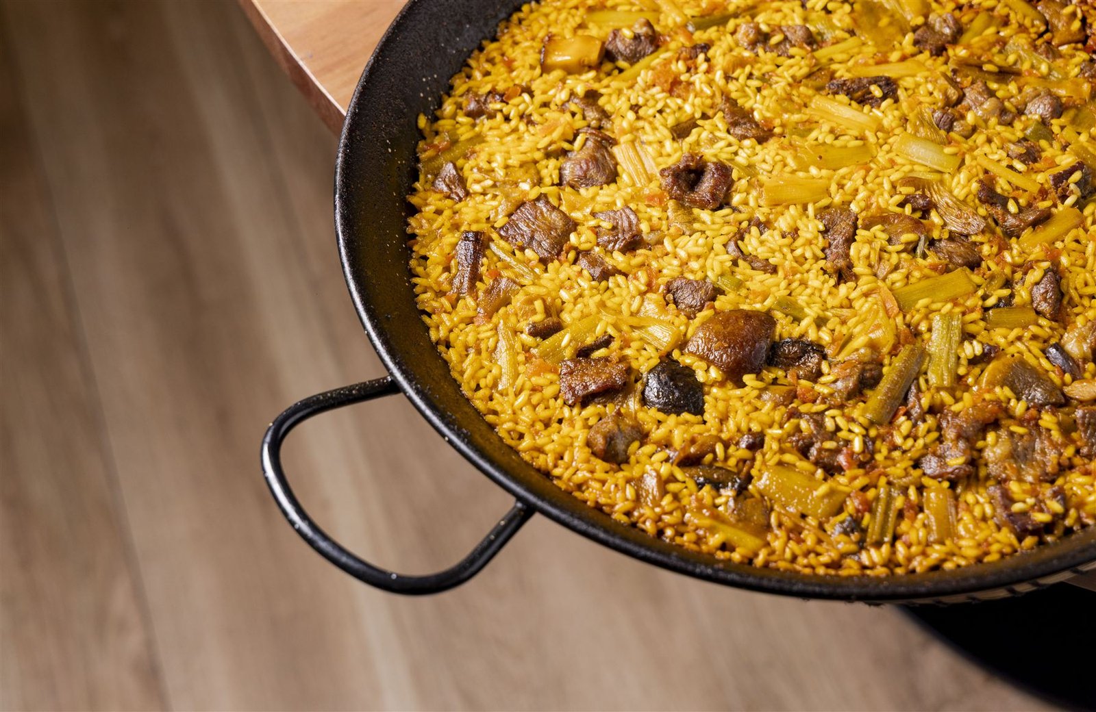 Paella de plumilla ibérica con boletus en paellera al fuego