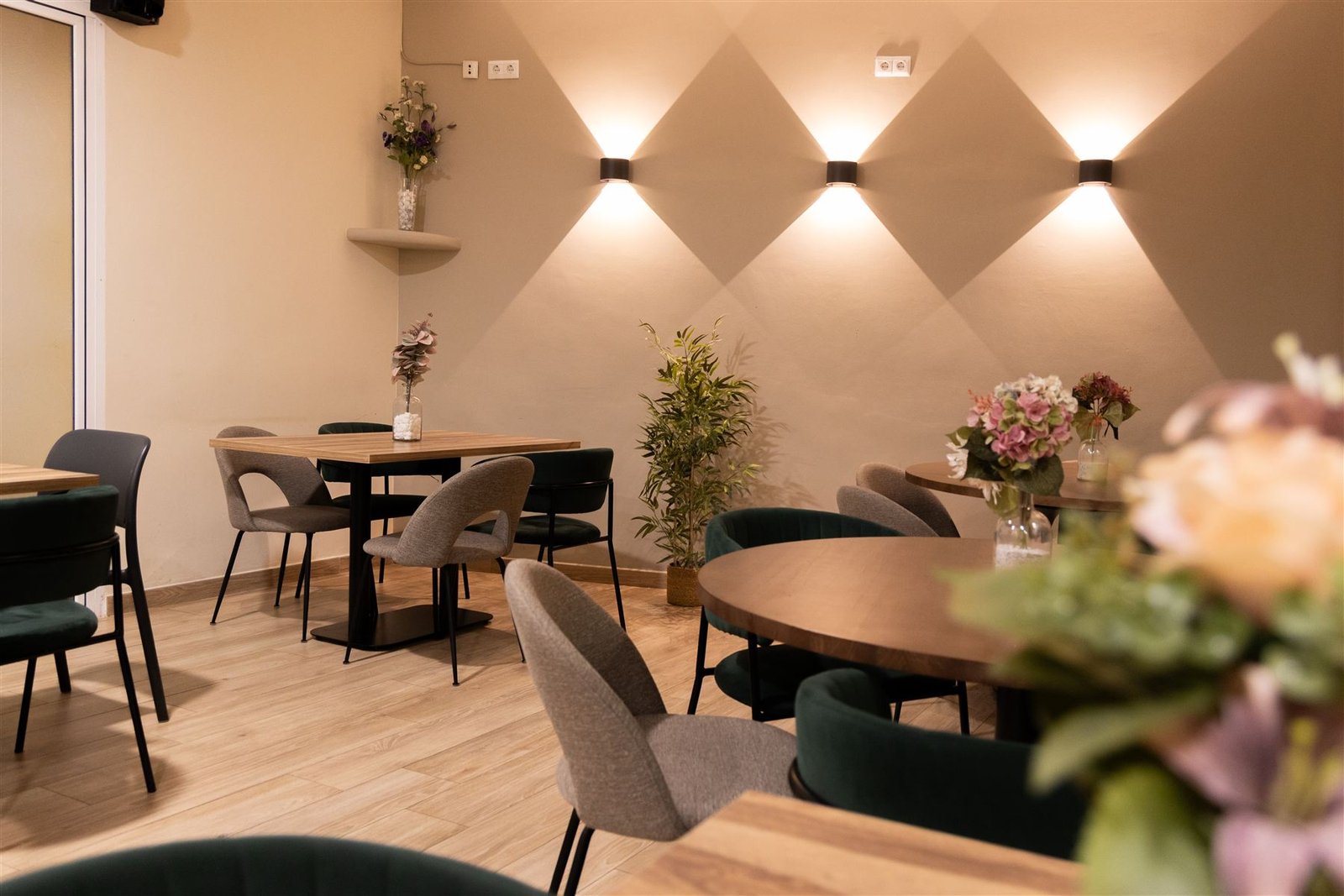 Rincón del comedor con sillas verdes y flores secas